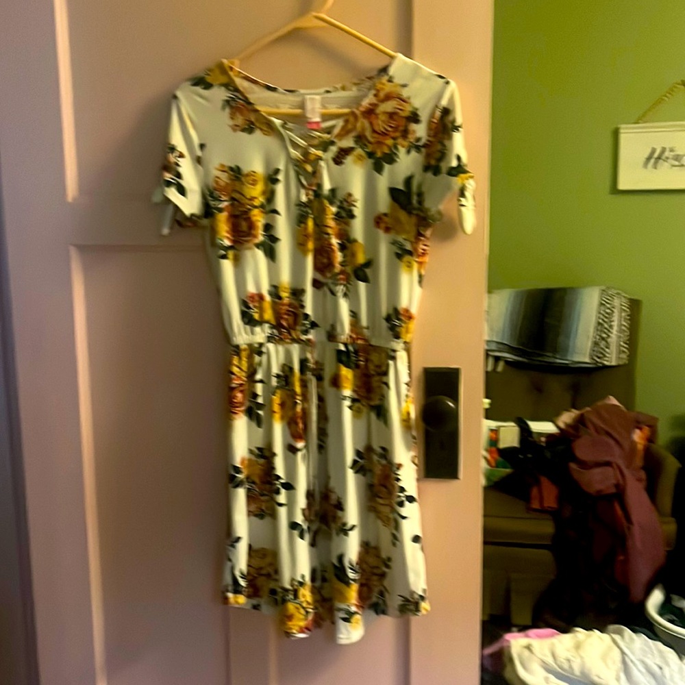 This is a short, floral dress with a lacy back and bows on the shirt sleeves